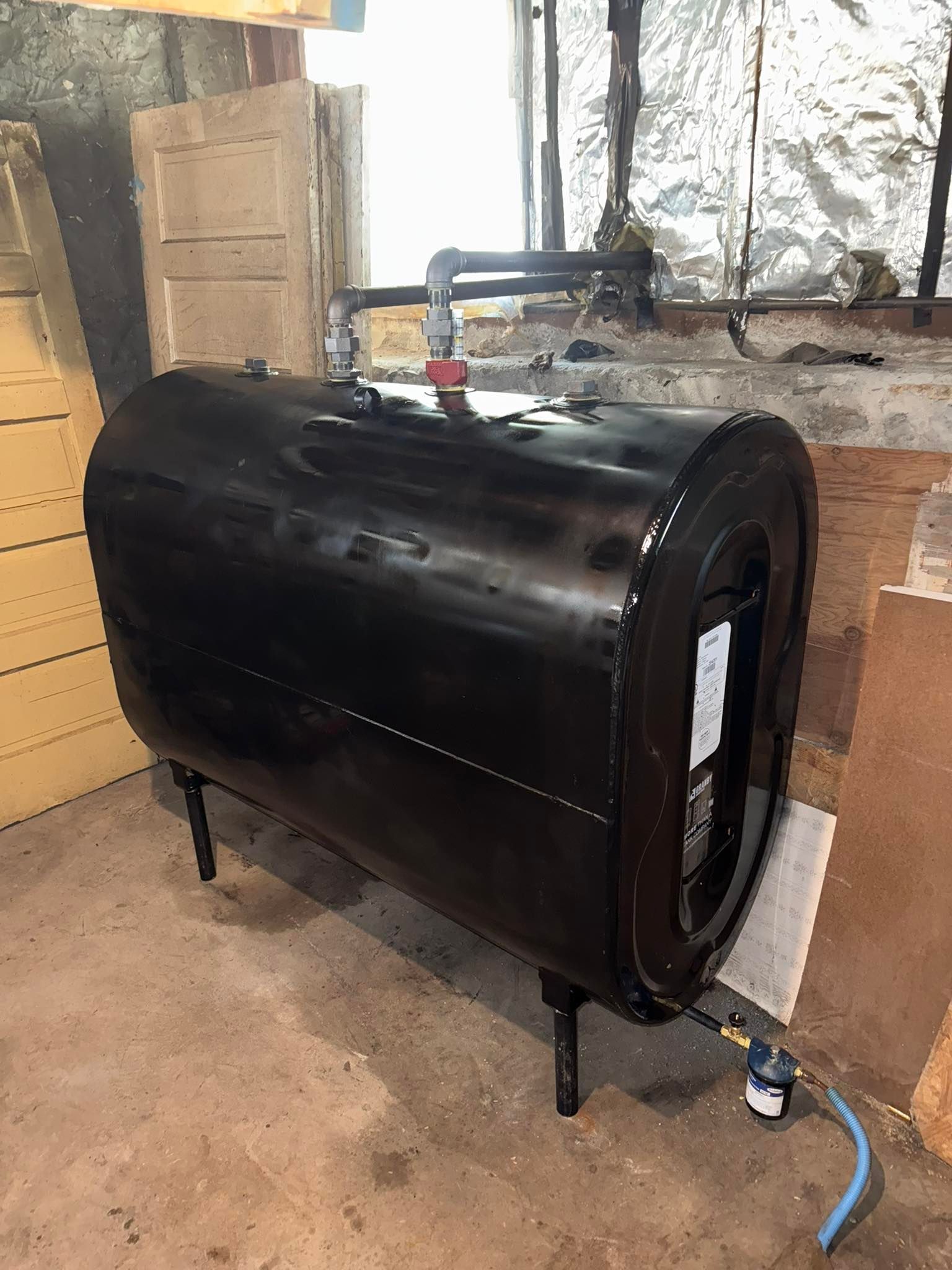 Black steel oil tank installation with fill and vent piping